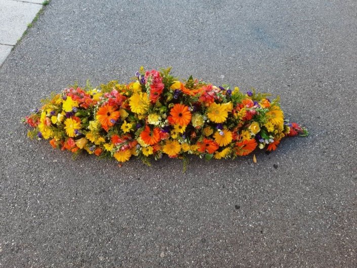 Composition florale couleurs tropicaux en long pour le deuil